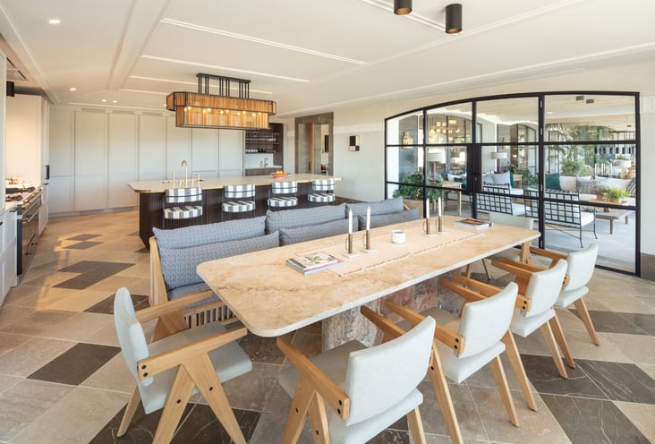 Kitchen and dining area at Villa La Gratitud with stone table, designer chairs, and garden views.