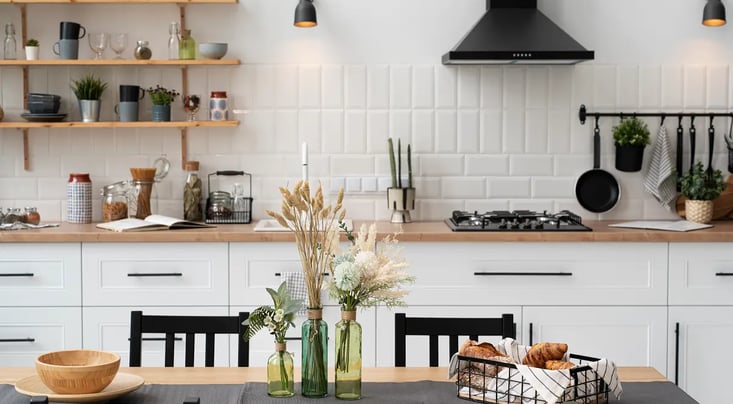 Modern kitchen with flowers, croissants, and decorative kitchenware.