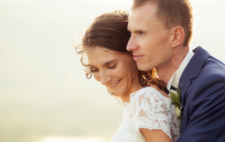 a bride and groom embracing each other in a field