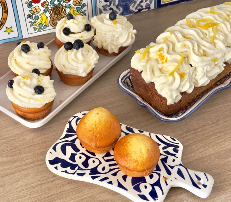 Cake au citron avec des cupcakes à la myrtille et crème chantilly.