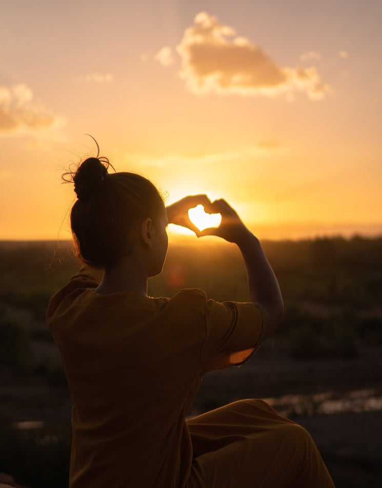 a woman holding a heart shaped heart with her hands
