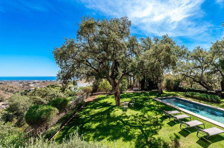Pool surrounded by oak trees and sea views from Finca Santa Katerina