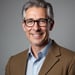 a man in a suit and glasses smiling