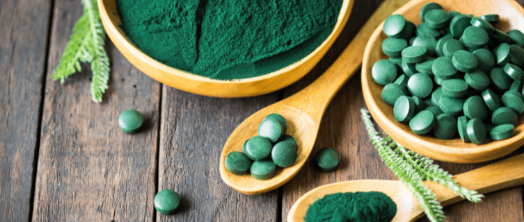 Un bol de spiruline en poudre et un autre bol avec des comprimés de spiruline
