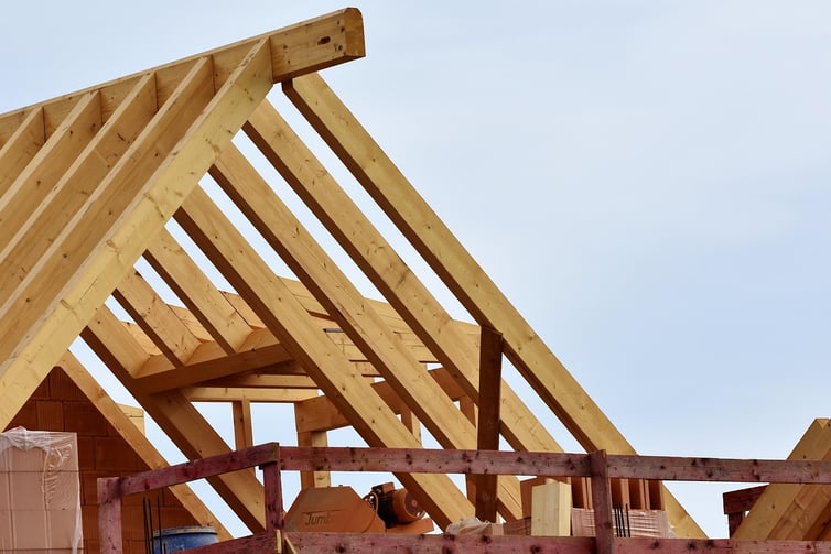 Roof trusses made out of wood during the building phase with wooden scaffolding attached