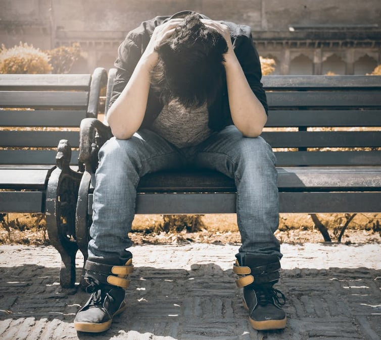 a person sitting on a bench with a backpack