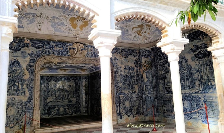 A grotto with blue and white tiles in complicated pattern and latticework over a triple archway 