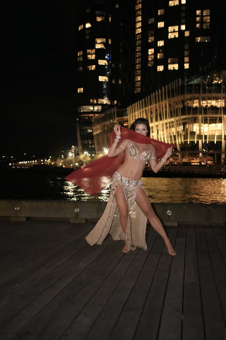 Aleksandra dancing with a red veil against the Sydney night skyline