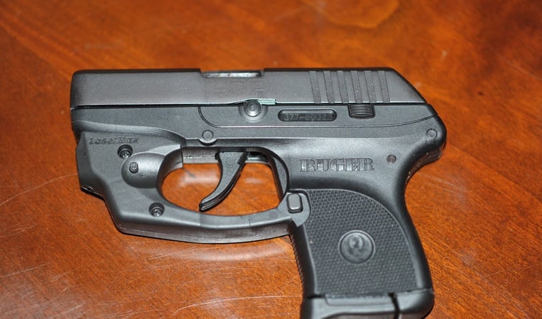 Ruger LCP with laser laying on a wood table