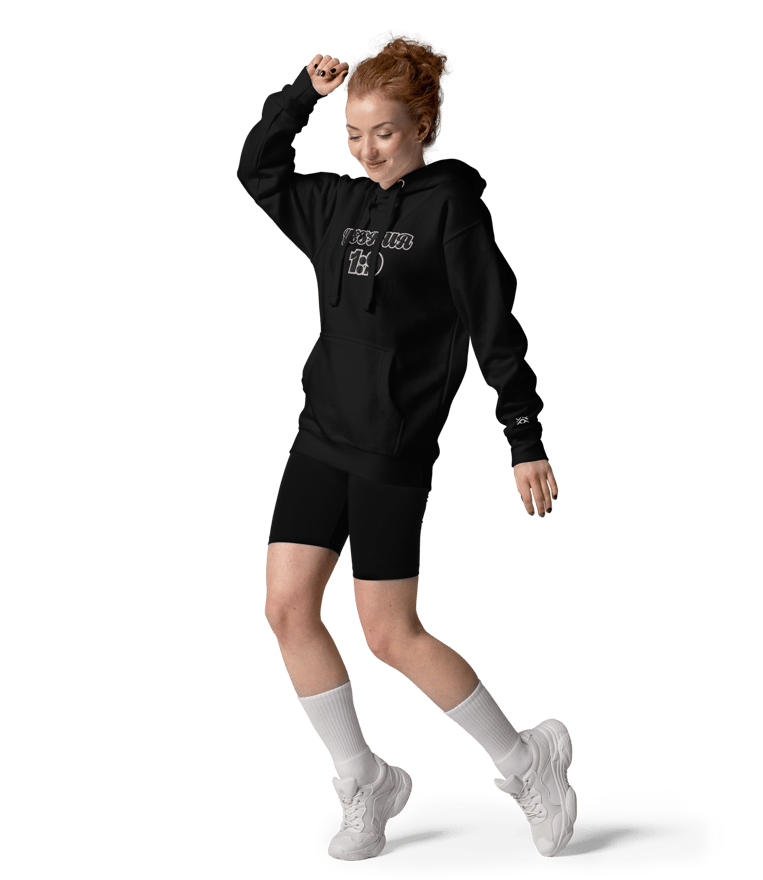 a woman in a black hoodie and shorts is jumping in the air