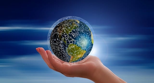 una mano sosteniendo una bola del mundo interconectada