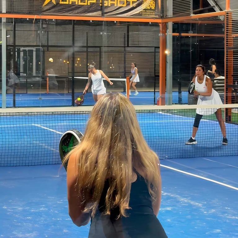 Mujeres jugando pádel en cancha de club deportivo