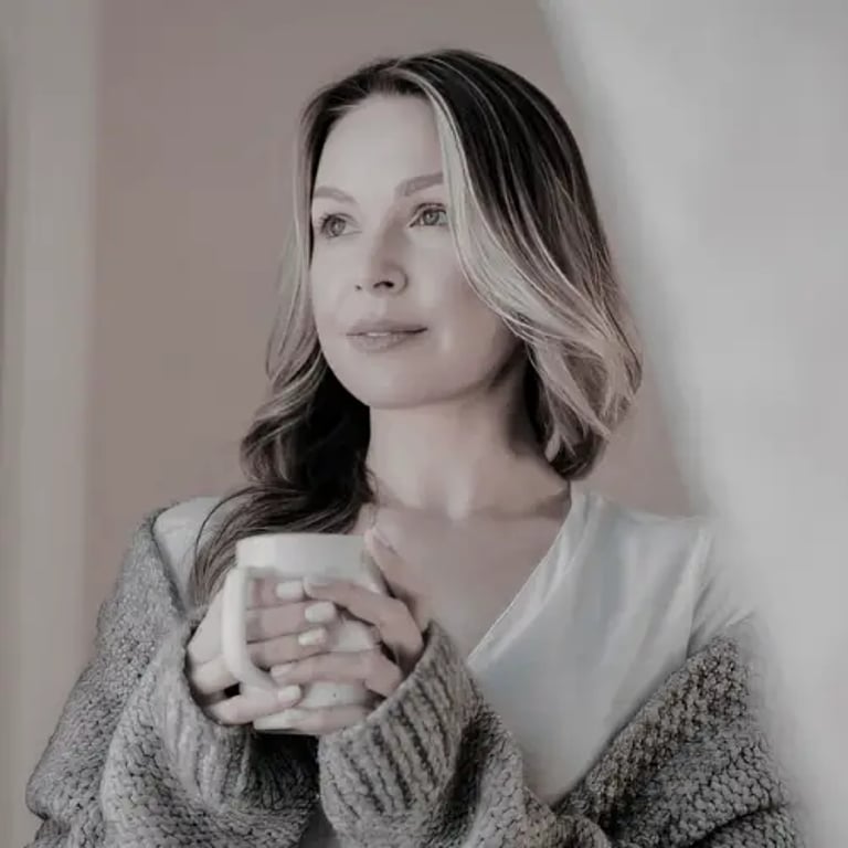 A blonde woman in a cozy knit cardigan holding a warm mug of coffee during a relaxing morning.