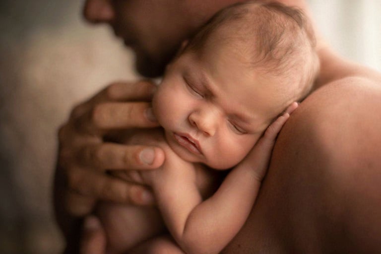 Noworodek w objęciach taty  fotografia noworodkowa.