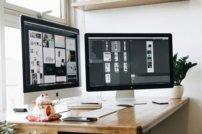Escritorio con doble pantalla mostrando wireframes de diseño web estratégico