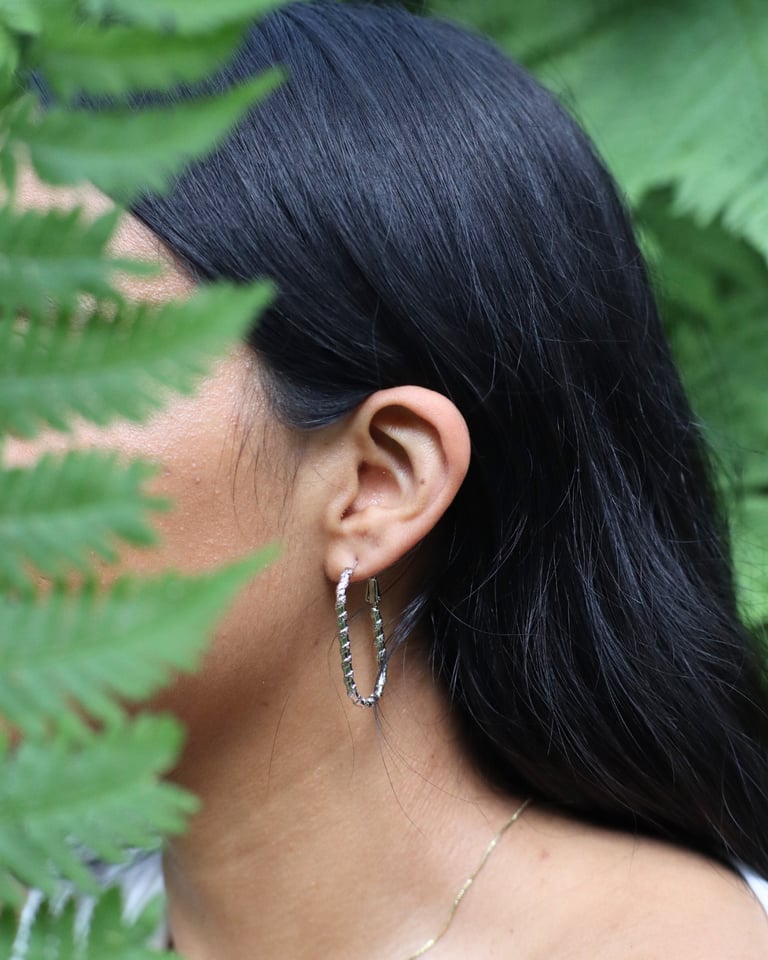 Aretes largos plateados usados por una mujer