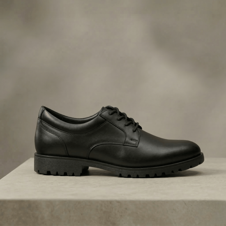 Zapato de vestir de cuero negro, con cordones y una suela gruesa y texturizada,