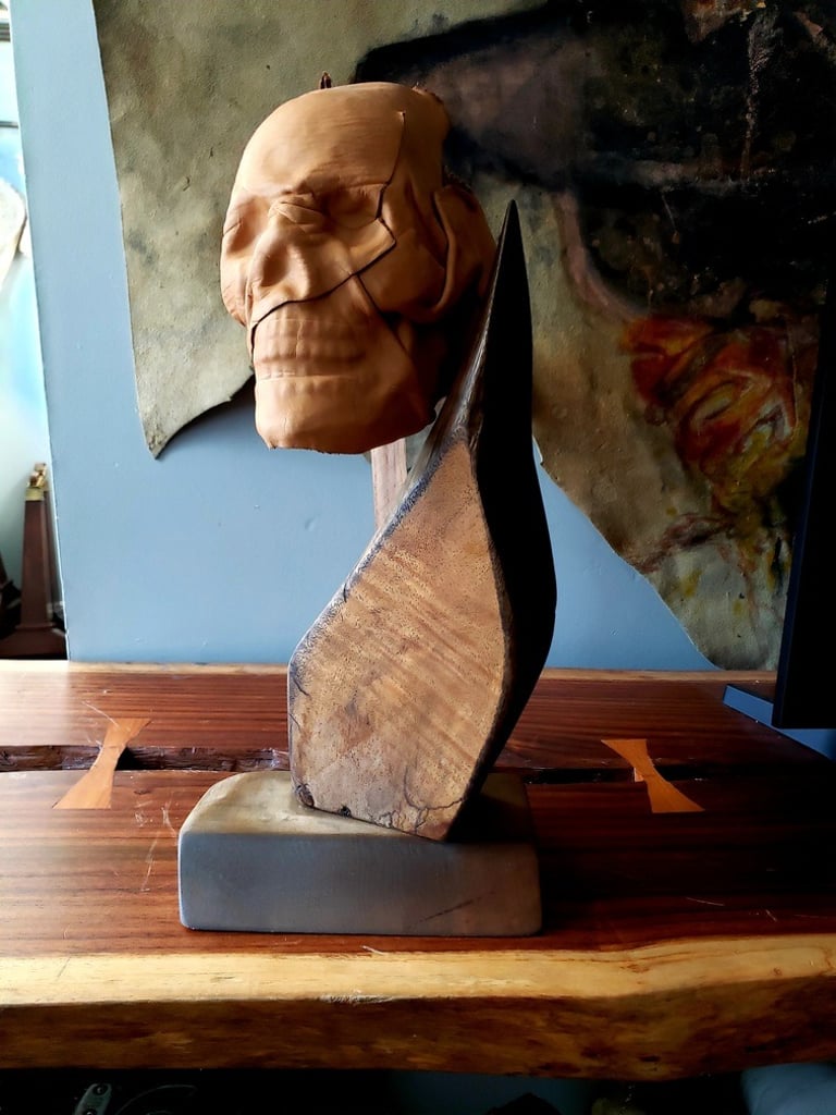 escultura de madera con craneo de piel