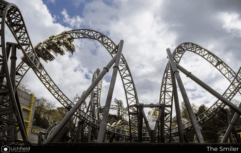 A Roller coaster in the shape of eyes and a smile with a cart on a loop to the left  