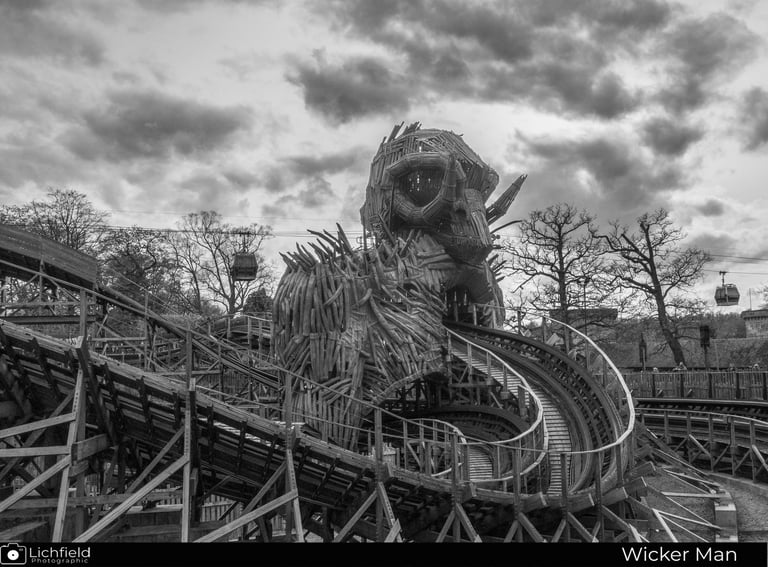 wooden roler coaster track with thr rear of the wicker man and some sky ride gondolas 
