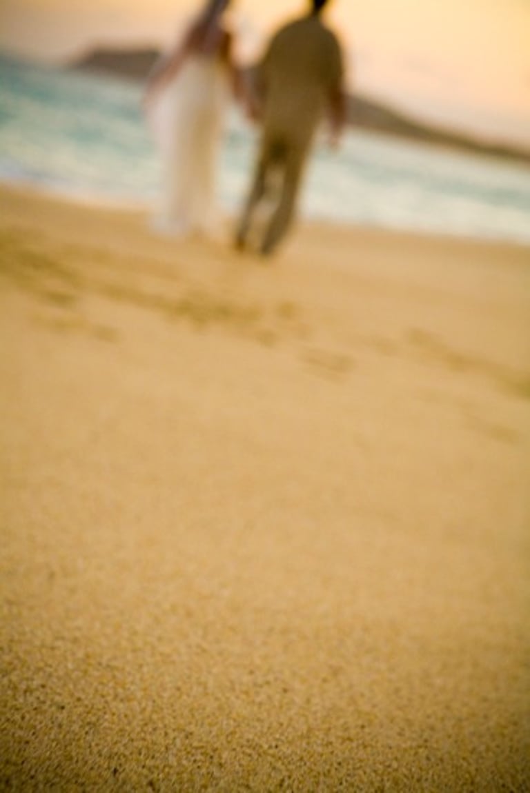 Beach Destination Wedding. Blurred background. Bride and Groom Walking on the beach. San Jose del Cabo, Mexico.