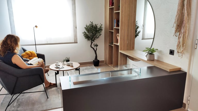 Interiorismo de zona lectura con chimenea de bioetanol incrustada en mueble en San Antonio de Benagéber