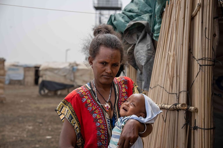 Mother holding her baby in a refugee camp in Sudan.