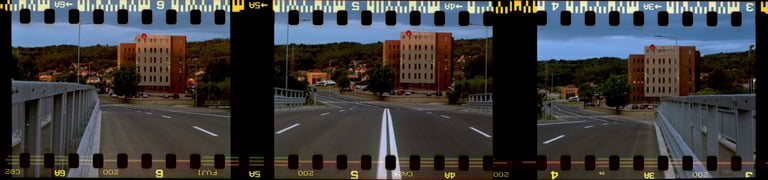 Composed photo of a bridge leading to a building, dark hill in the background