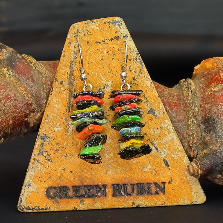 Kunstvolle Ohrringe aus schwarzen und bunten, übereinander gestapelten Holzstücken