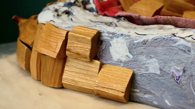 Nahaufnahme heller, naturbelassener Holzscheite bei ihrer Verarbeitung zu einem kunstvollen Spiegelrahmen