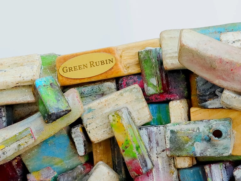 Ausschnitt eines Spiegelrahmens aus kleinen, bunten Holzscheiten mit GREEN RUBIN Logo