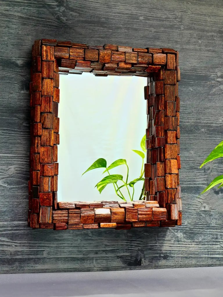 Spiegel mit rustikalem Rahmen aus vielen dunkel lasierten Holzscheiten