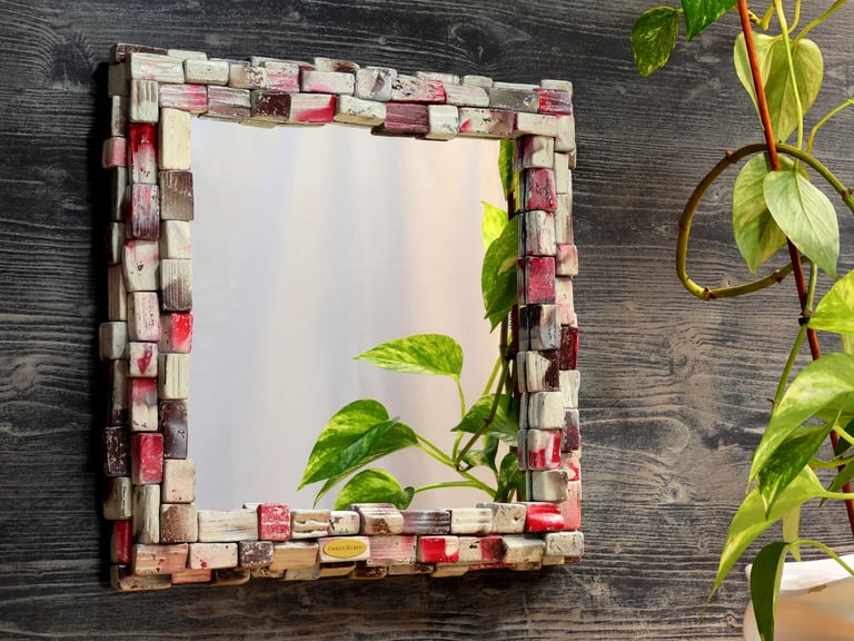 Unikaler Spiegel mit kunstvollem Rahmen aus weißen, braunen und roten Holzscheiten