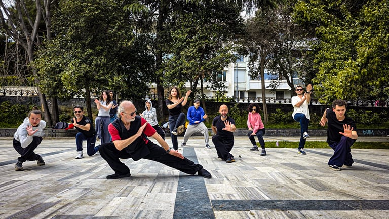 Esat Ataç leading a Tai Ji performance at İnönü Park for World Tai Ji Day 2025, students posing in martial forms.