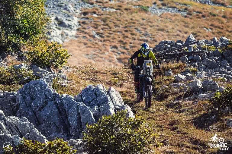 pilote moto descend chemin rochers herbe paysage croatie