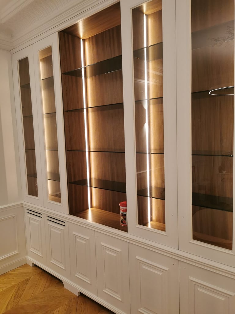 bibliothèque moulurée laquée avec rétroéclairage et étagères verre alliant ancien et moderne