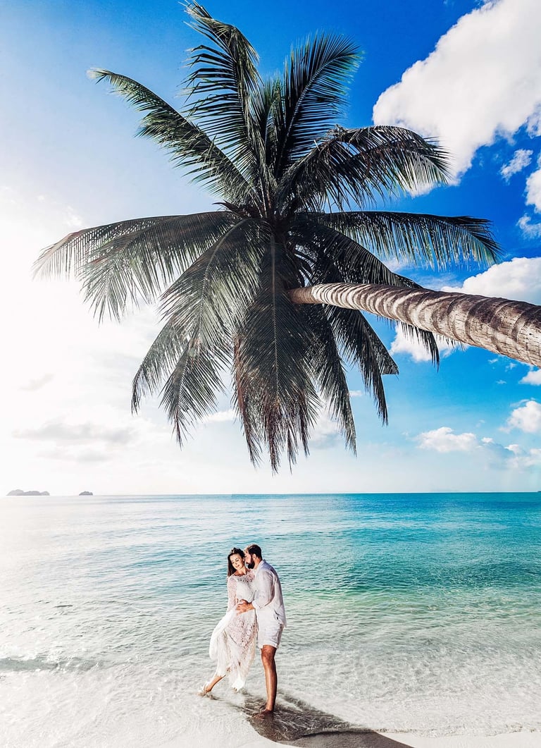 Wedding couple kissing under palm tree on Bai Sao