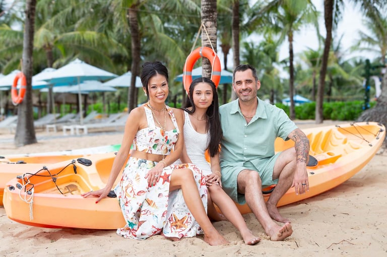 Family beach photoshoot near kayaks in Phu Quoc