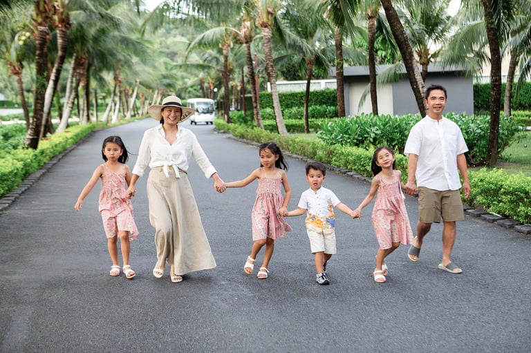 Family smiling walking together on palm lined resort road