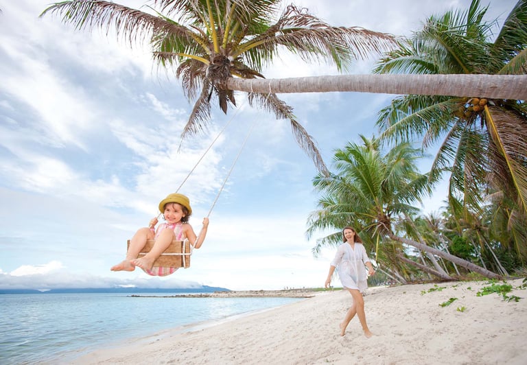 Little girl on coconut swing beach in Phu Quoc