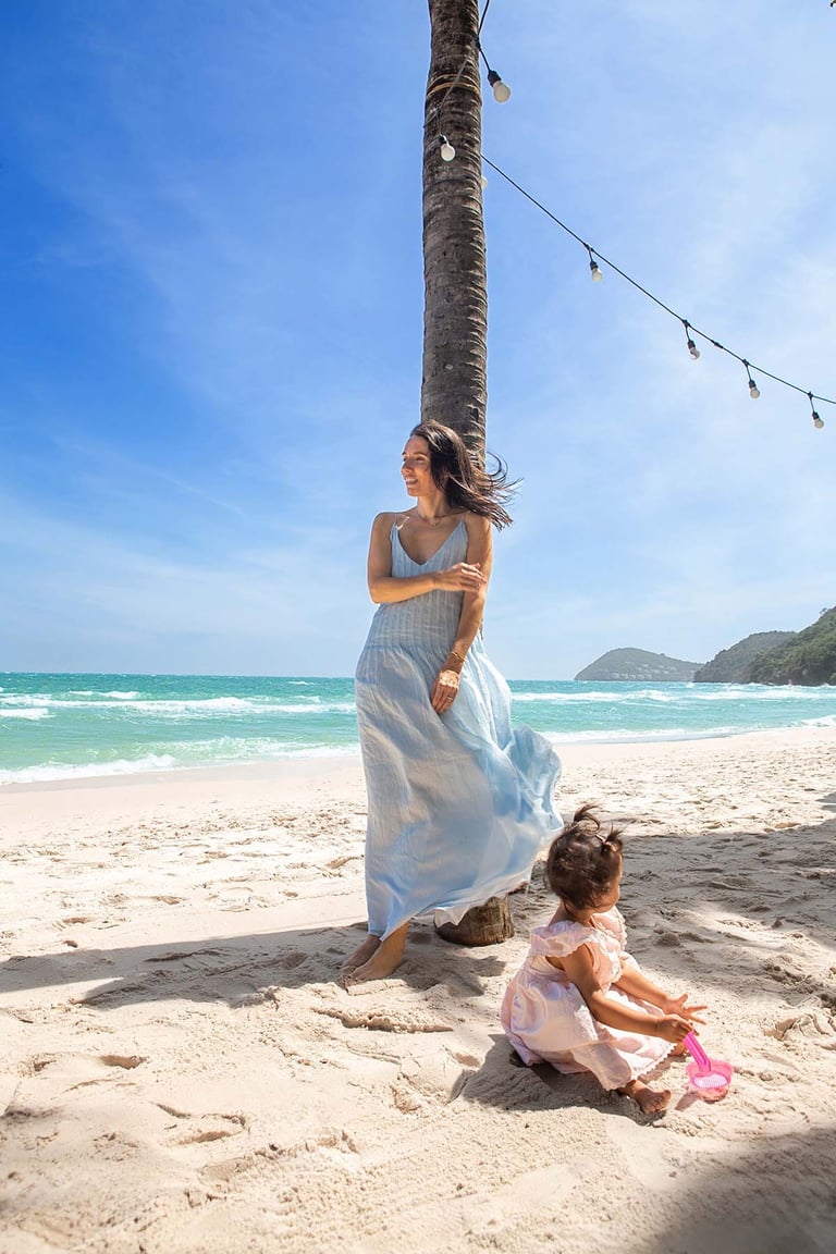 Mother and toddler playing under palm on Phu Quoc beach