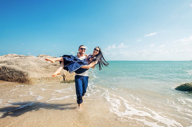 Playful couple on rocky beach in Phu Quoc