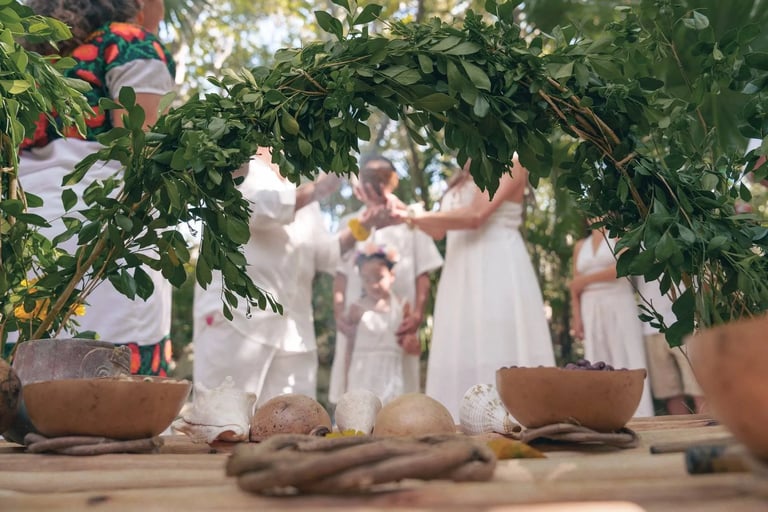 una familia al fondo frente a un altar maya en su ceremonia de boda