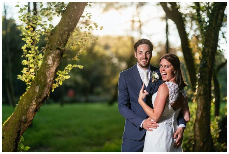 Playful bride and groom portrait at Llanerch Vineyard wedding, laughing together in golden evening light.