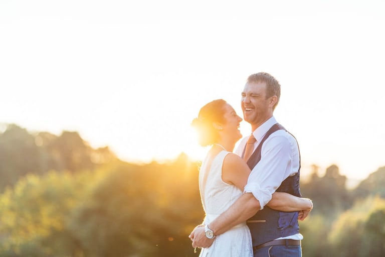 Golden hour wedding photography at Ceridwen Centre in West Wales, capturing a couple laughing in the sunset