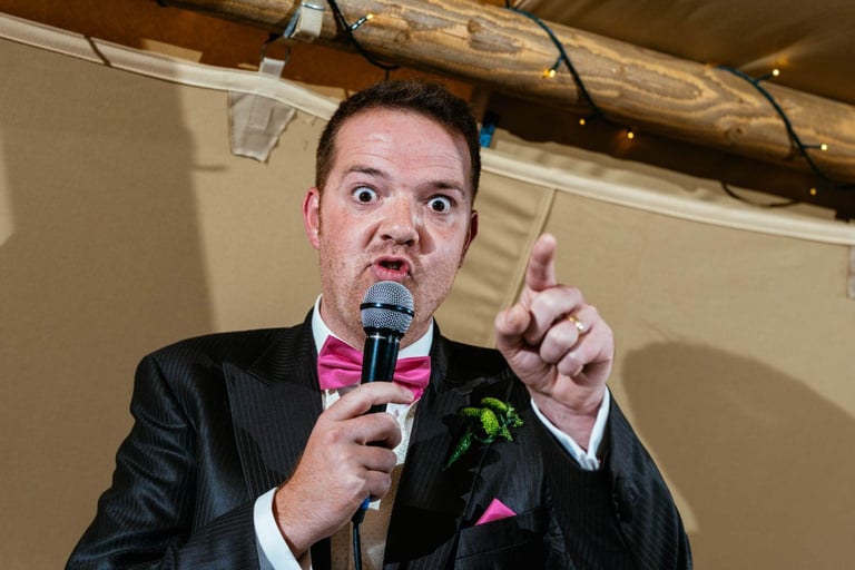 Funny wedding speech moment with guest in pink bow tie, captured at a South Wales wedding celebration.