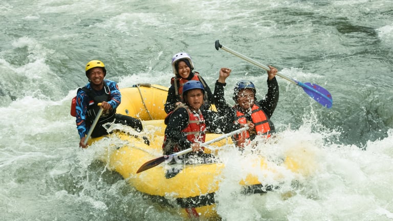 Perahu karet melintasi jeram deras dalam paket rafting ekstrem