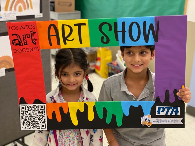 2 children behind an artistic picture frame