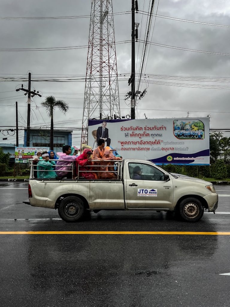 Car transporting workers in the rain in Indonesia