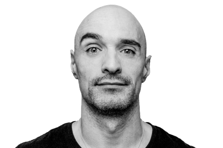 Close-up portrait of a bald man in black and white.